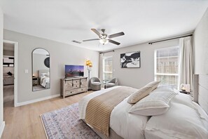 A bedroom with a bed, a ceiling fan, a dresser, a chair, a rug, and a window with blinds. - Houston Getaway | Yard BBQ | Games | WiFi | Pets (Houston)