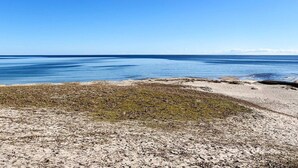Une plage avec un ciel dégagé et une mer calme.