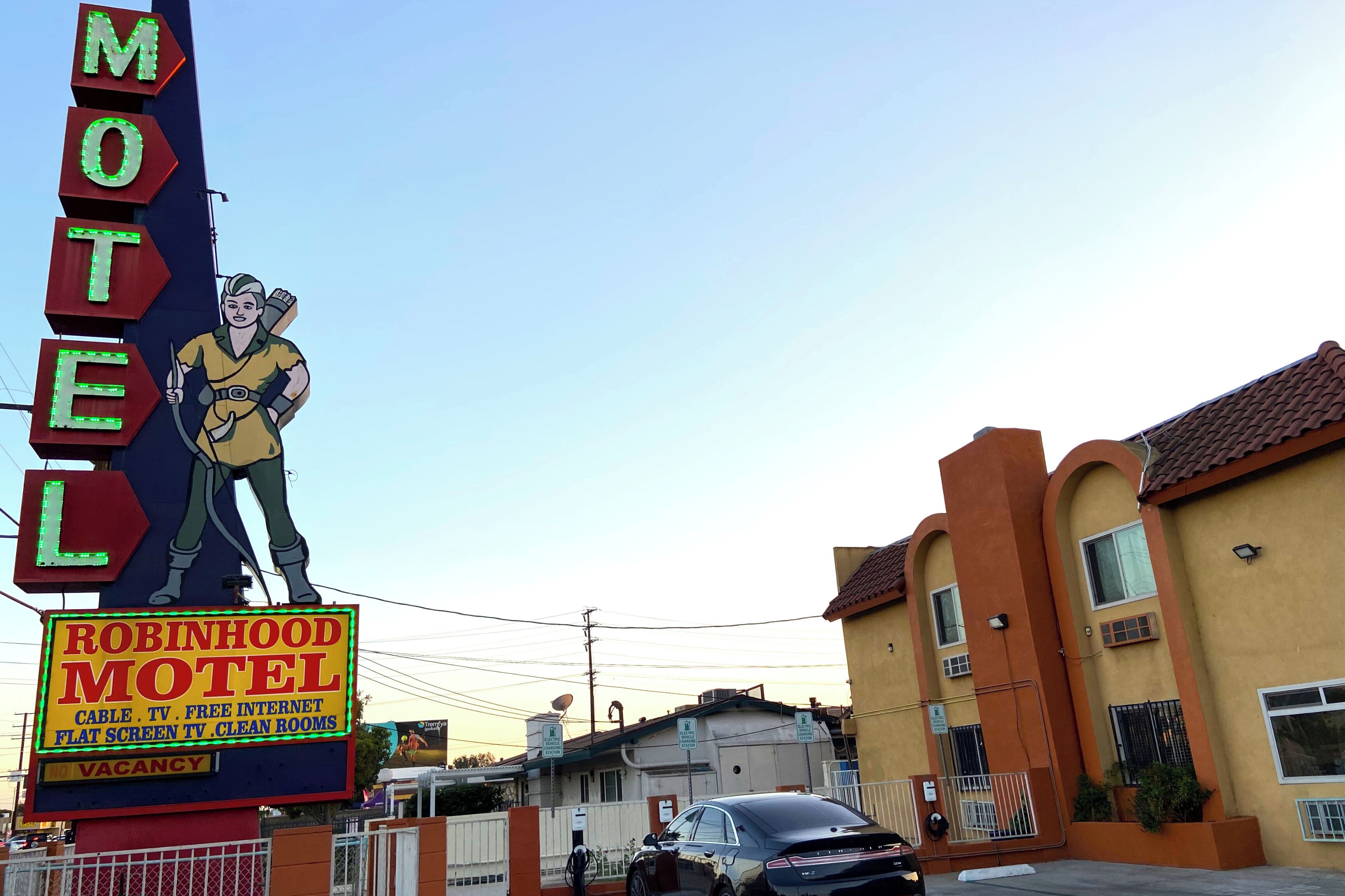 Letrero de motel con un personaje de caricatura, un letrero de neón y la leyenda 'Vacancy'.