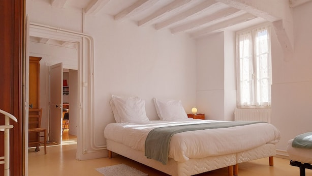 Una camera da letto con un letto, un comodino e una finestra.