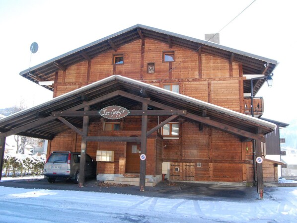 A wooden building with a covered entrance and a sign reading "Les Goofy's".