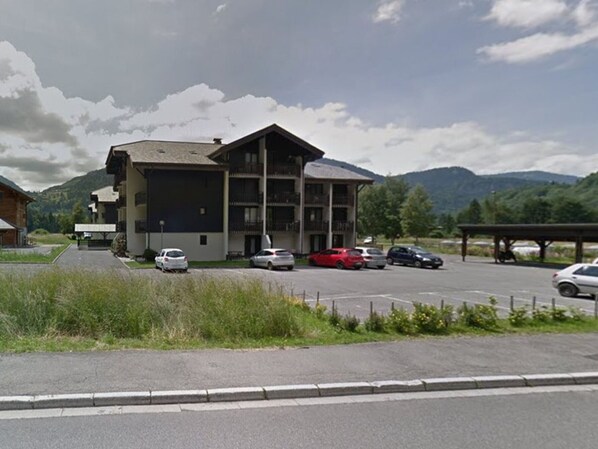 A multi-story building with a parking lot in front.