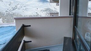En balkon med udsigt over et sneklædt bjerg.