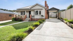 A single-story house with a front porch, a garage, and a well-maintained lawn.