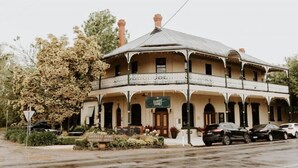 A historic hotel with a distinctive architectural style, featuring a central dome and multiple balconies. - The Rabbit Hole Inn at Harvest Home (Avenel)