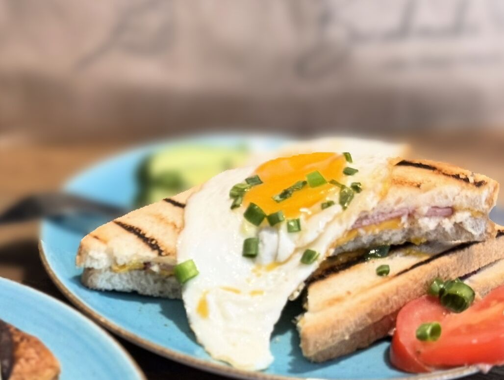 A sandwich with a fried egg on a blue plate.