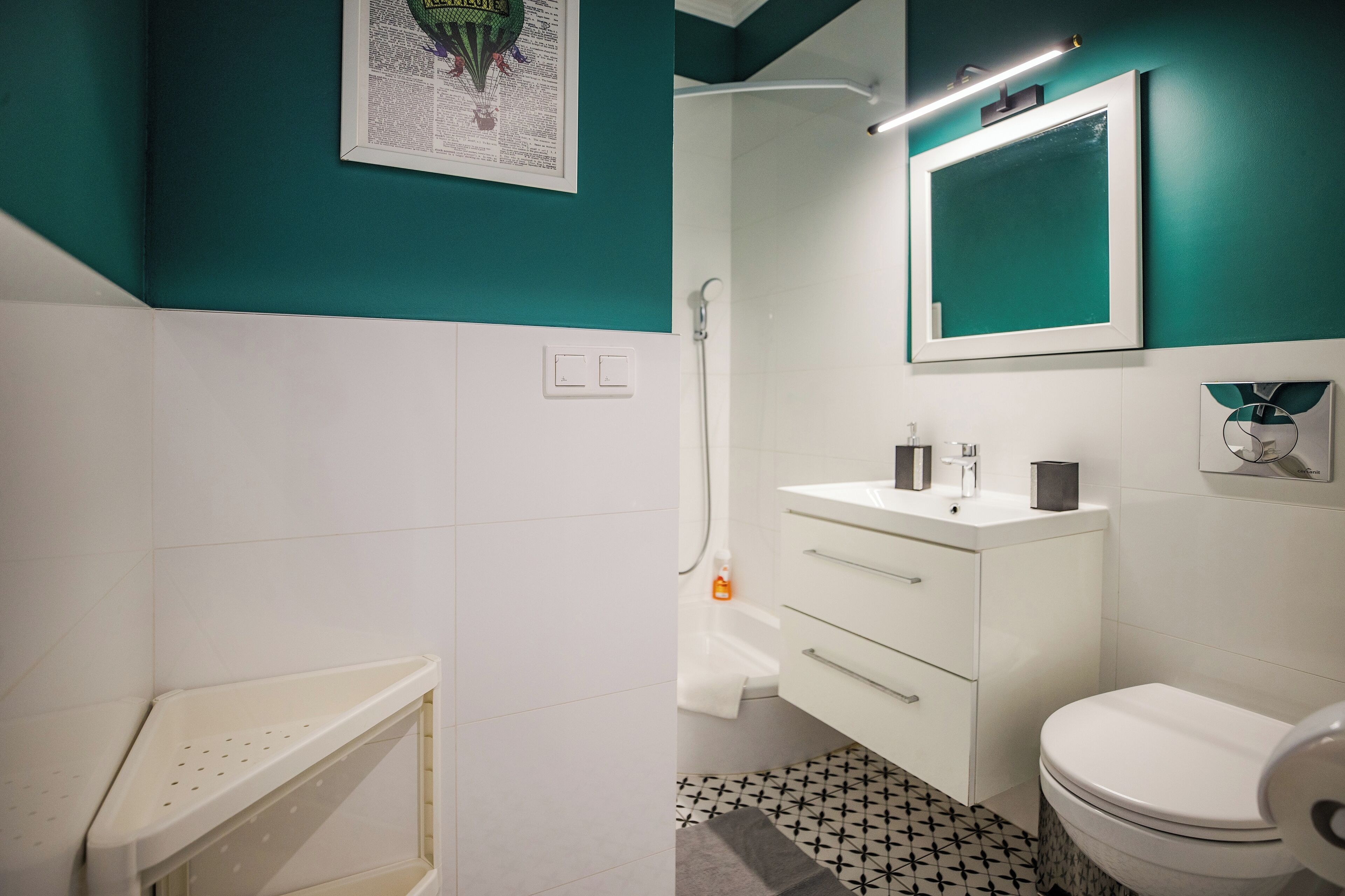 A bathroom with a white sink, a white toilet, and a shower.