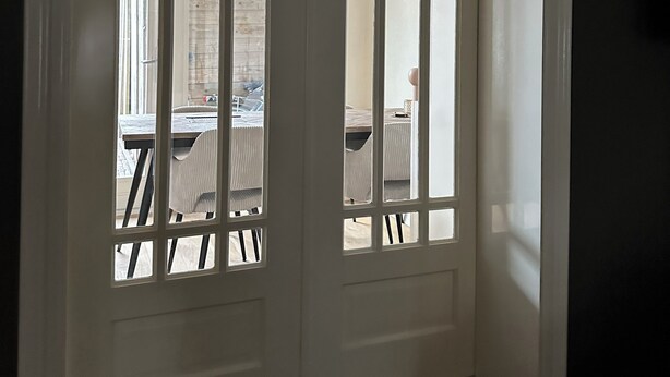 A white door with vertical bars, leading to an outdoor area with a table and chairs. - Entire house in downtown Medemblik  (Medemblik)