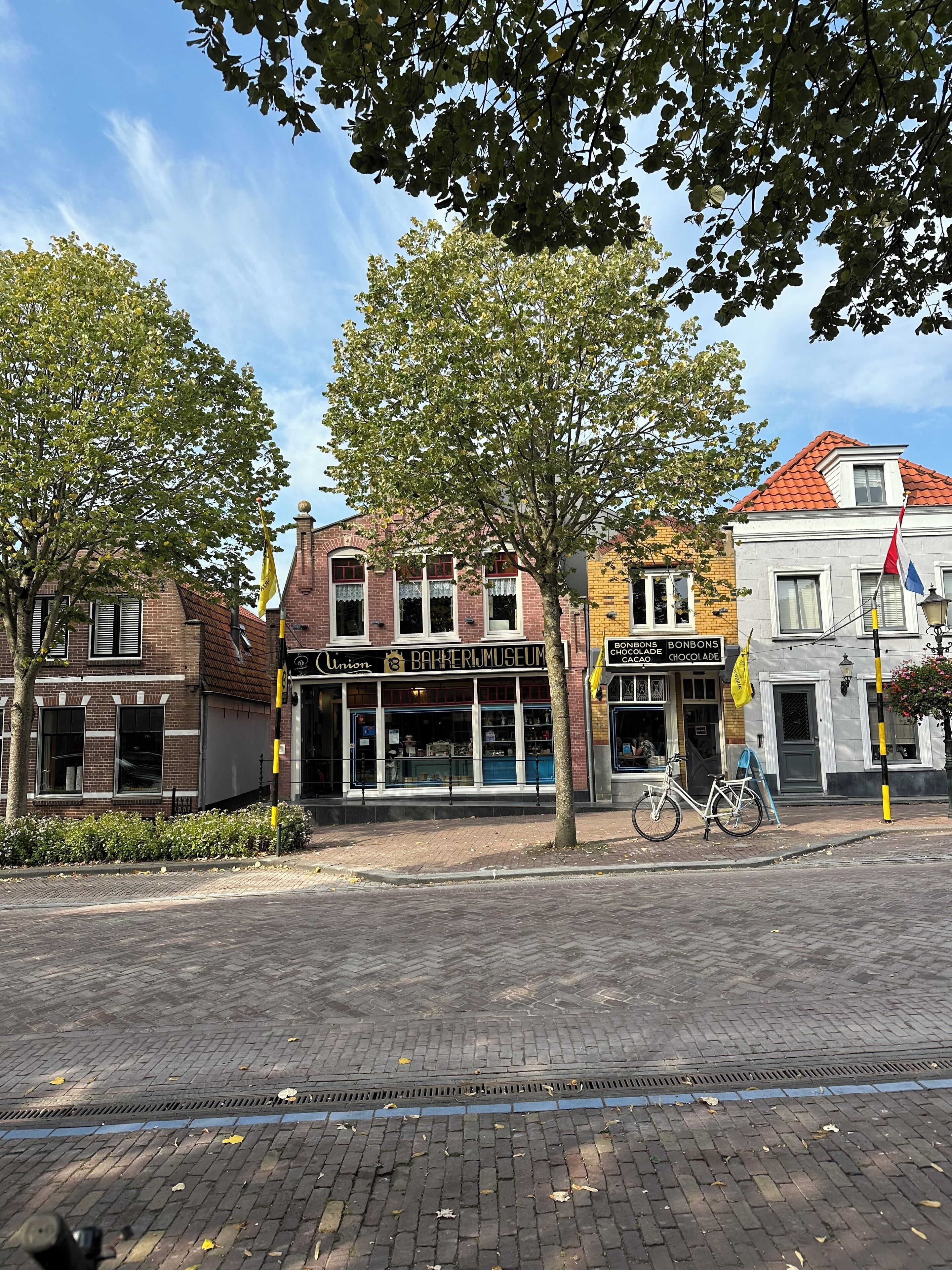 Een straat met gebouwen, waaronder een bakkerijmuseum en een chocolade café.