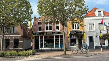 Een straat met gebouwen, waaronder een bakkerijmuseum en een chocolade café.