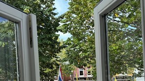 A view through a window with a flag, a bicycle, and a building with a sign that reads "Union". - Entire house in downtown Medemblik  (Medemblik)