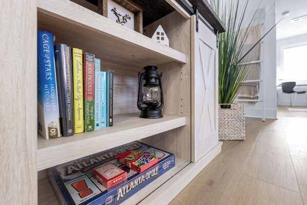 A wooden shelf with books, a lantern, and a board game.