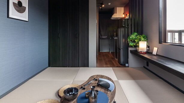 A modern interior with a tatami mat floor, a hanging paper lantern, and a minimalist design. - Oyadokinokuniya tamazonomachi (Nagasaki)
