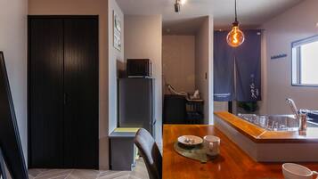 A modern kitchen with a wooden countertop, a sink, and a hanging light fixture.