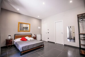 A modern bedroom with a bed, bedside tables, a mirror, and a wardrobe. - MEDUSA CILEA GUEST HOUSE (Naples)