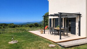 A patio with a table and chairs, a pergola, and a view of the landscape. - New Villa Sea and Mountain View - Calenzana, near Calvi  (Calenzana)