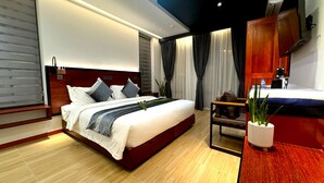 Un dormitorio moderno con una cama grande, un escritorio y una planta en maceta.