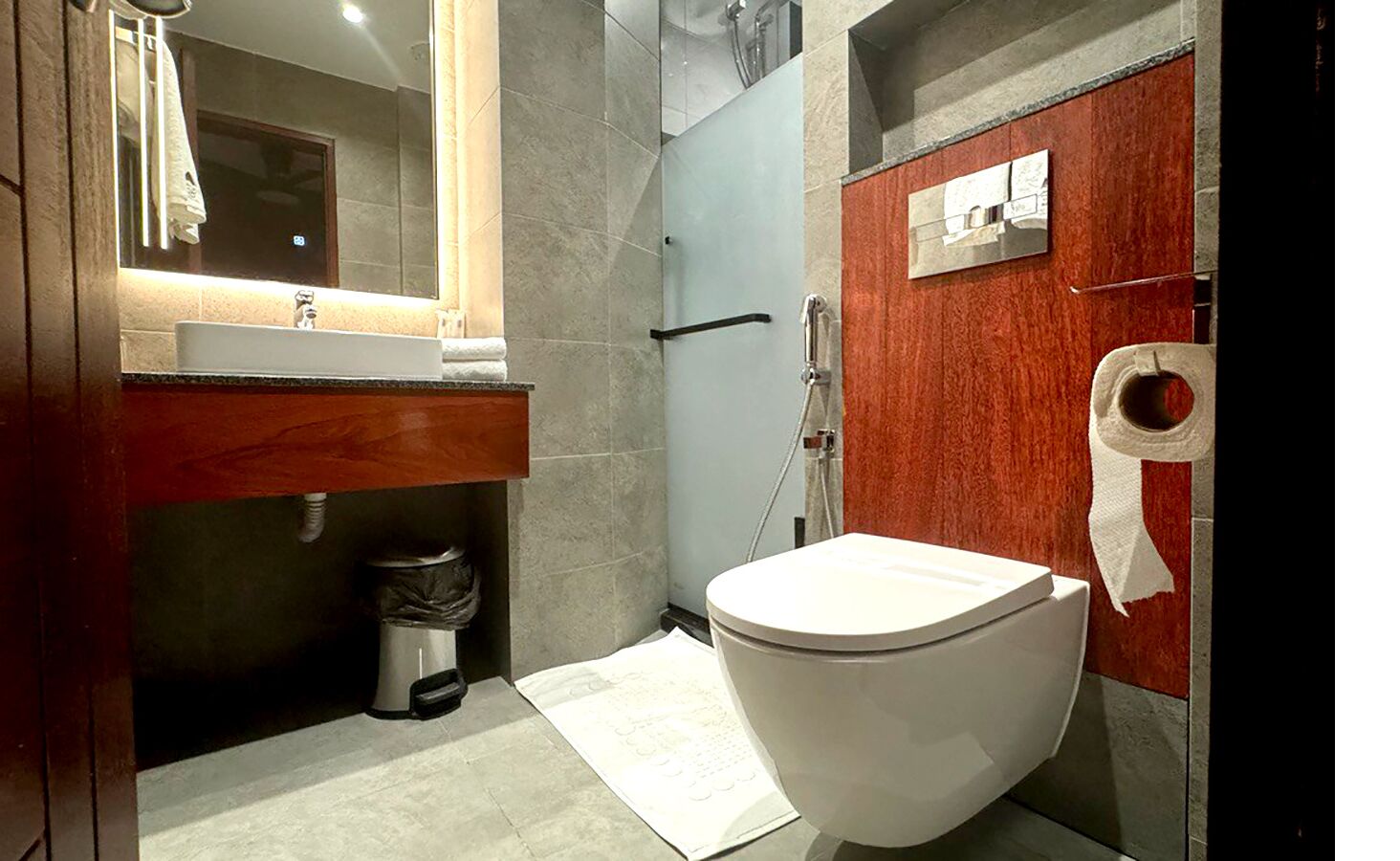 A modern bathroom with a toilet, sink, and shower.