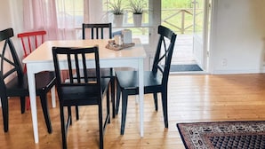 A dining area with a white table and black chairs, a black pendant light, and a clock on the wall. - 6 Person Holiday Home in Henan (Henån)