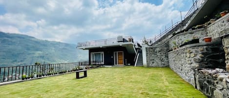 Un edificio moderno con fachada de piedra, techo plano y un pequeño porche delantero.