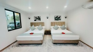 A hotel room with two beds, a window with a view of parked cars, and wall-mounted artwork. - Hibiscus Suites And Residences  (Nadi)