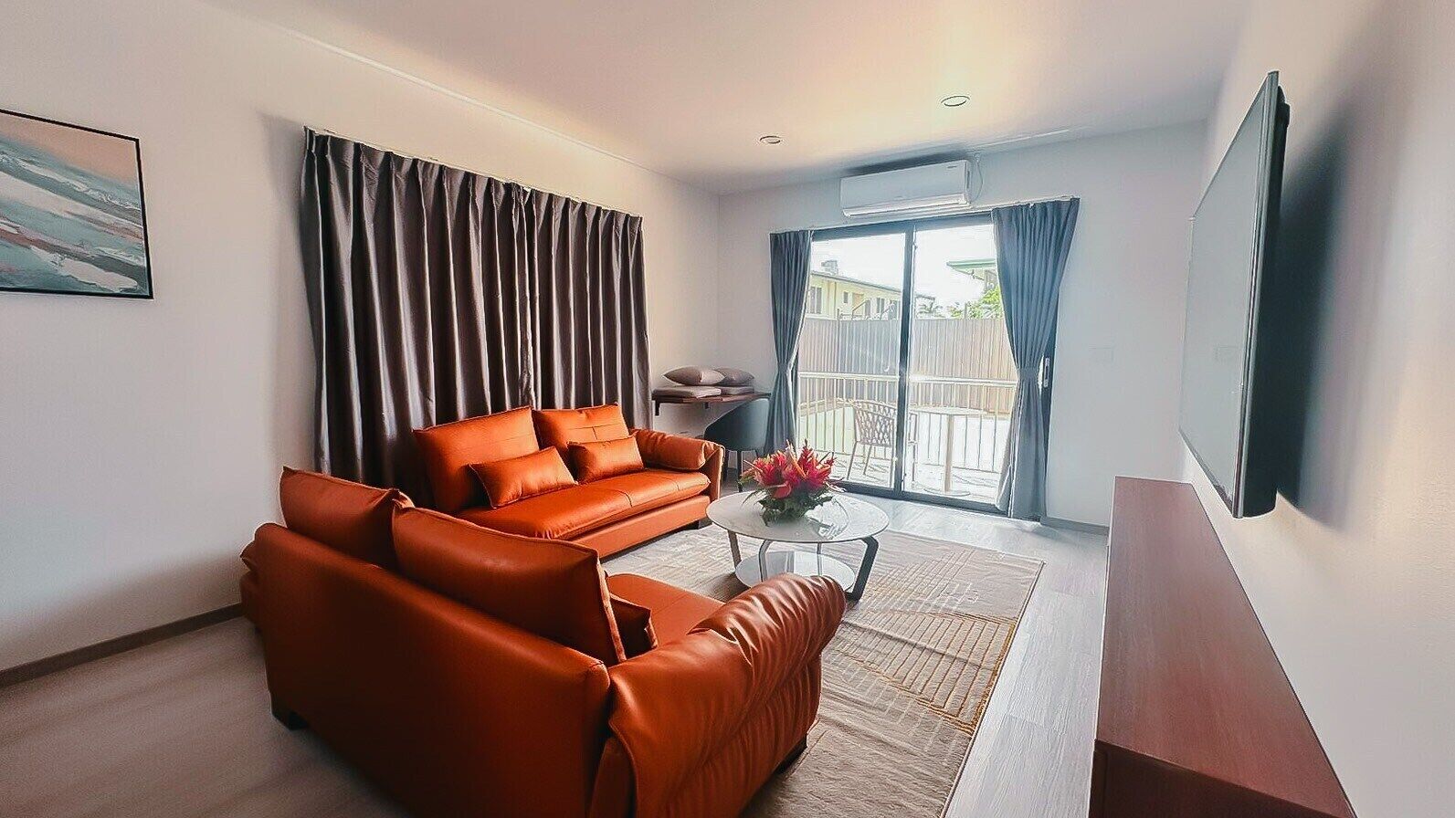 A modern living room with a sofa, a coffee table, and a TV.