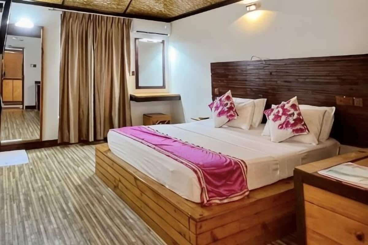 Ein Hotelzimmer mit einem hölzernen Bett, einem Nachttisch, einem Spiegel und einem Fenster mit Vorhängen.