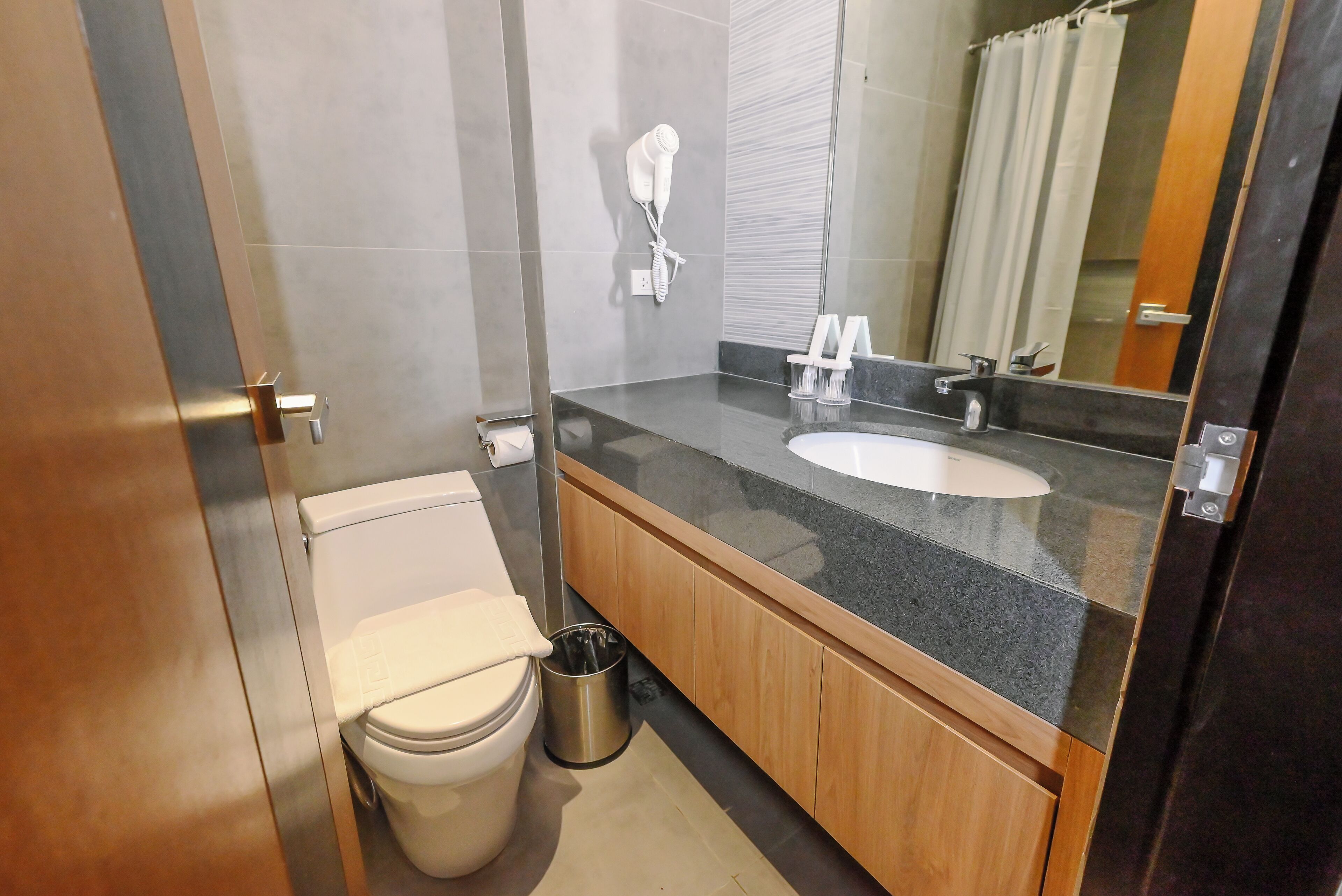 A modern bathroom with a toilet, sink, and shower.