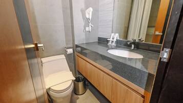 A modern bathroom with a toilet, sink, and shower.