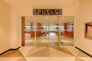 La entrada al restaurante Suele, con un interior moderno visible a través de las puertas de cristal.