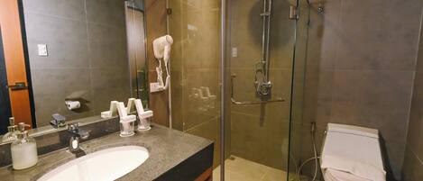 A modern bathroom with a glass-enclosed shower, a sink with a vanity, and a toilet.