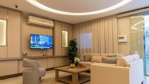 Un saló modern amb televisió plana, un sofà, una taula de centre i una planta en test.