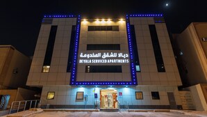 Un edifici amb un senyal que diu "DEYALA SERVICED APARTMENTS" i un videt blau LED.