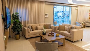 Un saló modern amb un sofà modular, una taula de centre i una planta gran en test.