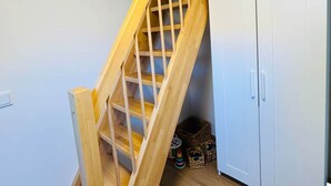 Eine Holztreppe mit einer Holzhandläufe und einer weißen Tür am Fuß.