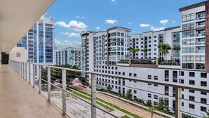 A modern apartment building with multiple floors, balconies, and a clear view of the surrounding area.