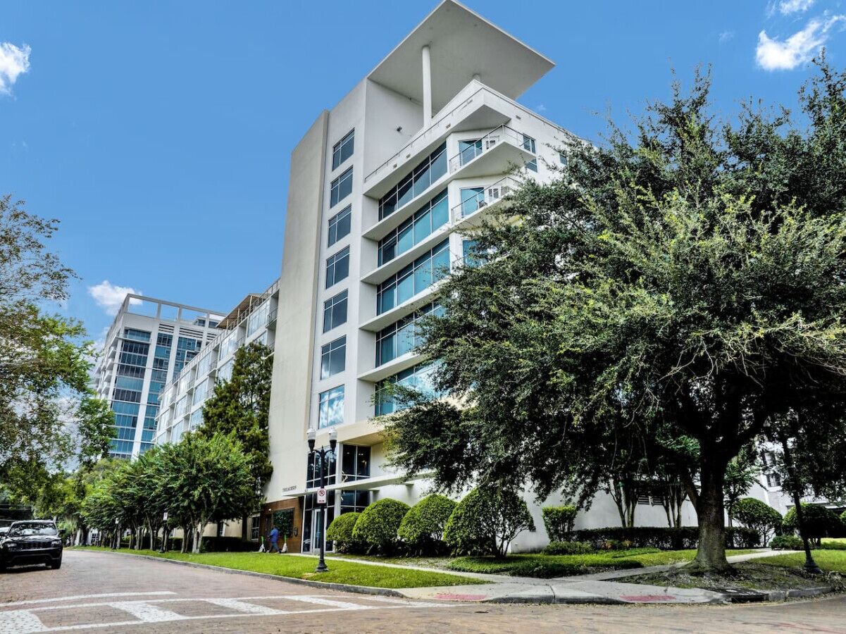 A modern multi-story building with a flat roof and large windows.