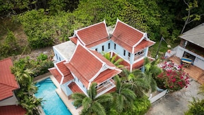 A multi-story building with a swimming pool, surrounded by lush greenery and palm trees. - Mountain View Villa Kamala (Kamala Subdistrict, Kathu District)