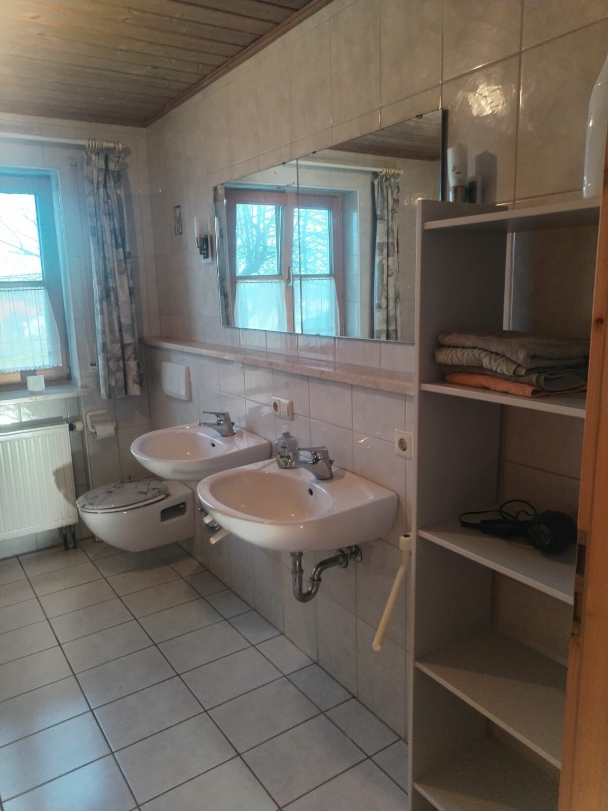Kylpyhuoneessa on kaksi pesuallasta, wc, peili ja ikkuna.