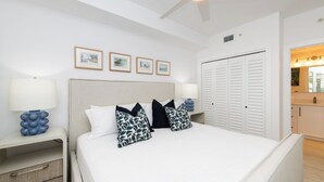 Un dormitorio con cama, mesitas de noche, ventilador de techo y armario.