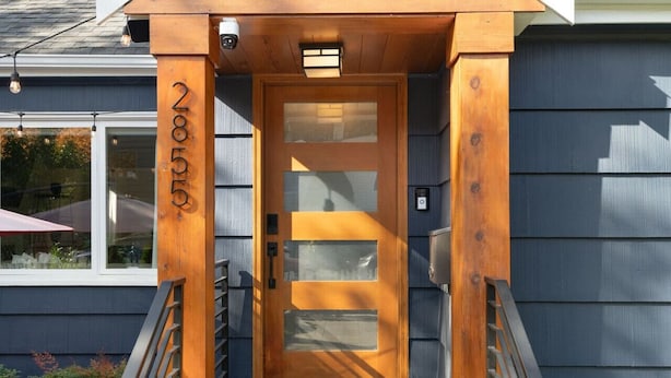 A wooden front door with a glass panel and a small window above it.