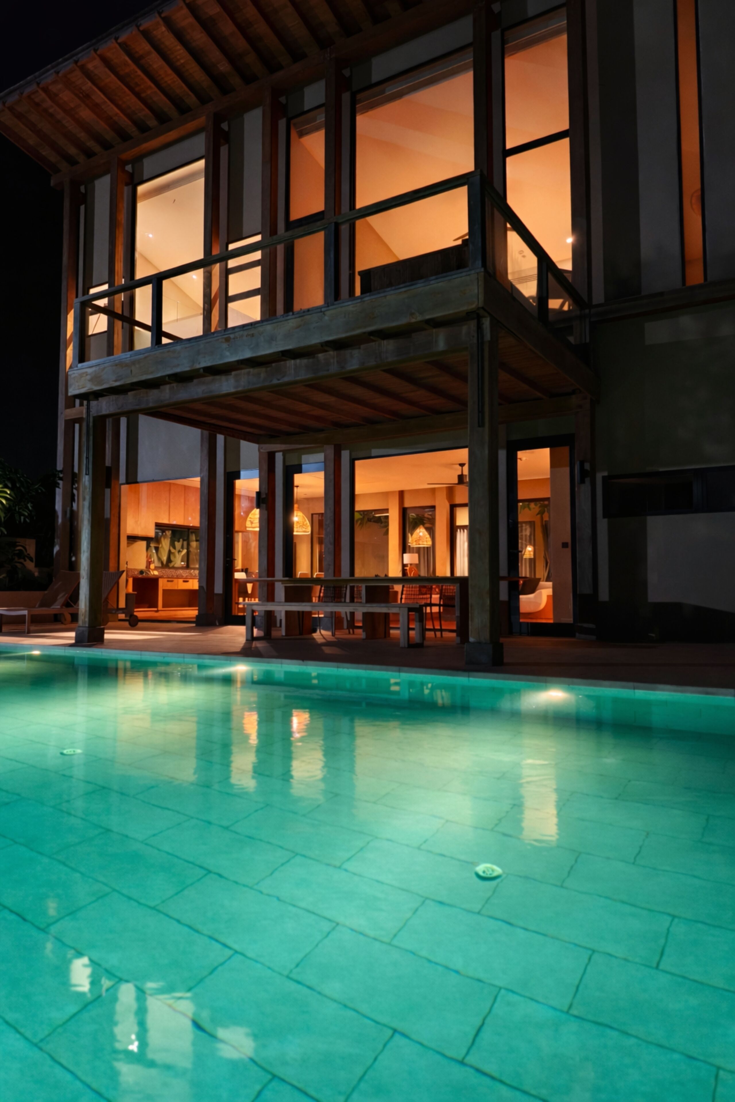 Un edificio moderno con piscina, ventanas amplias y un área de patio techada.