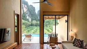 Un vaste espace de vie doté d’un grand téléviseur, de sièges confortables et offrant une vue sur la montagne et la piscine.