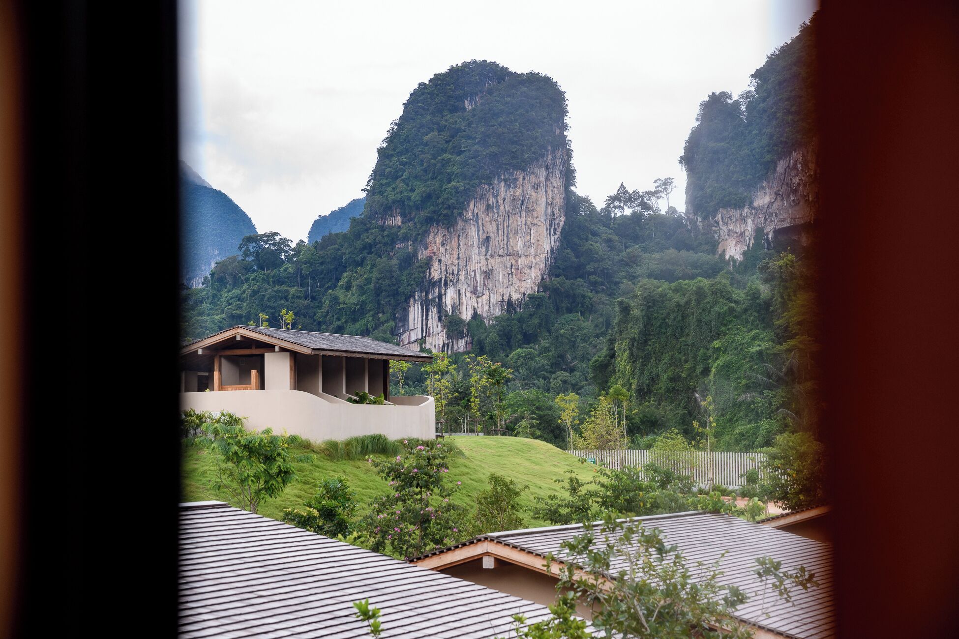 A mountain landscape with a building featuring a sloped roof and a flat roof structure in the foreground.