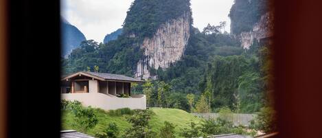 A mountain landscape with a building featuring a sloped roof and a flat roof structure in the foreground.
