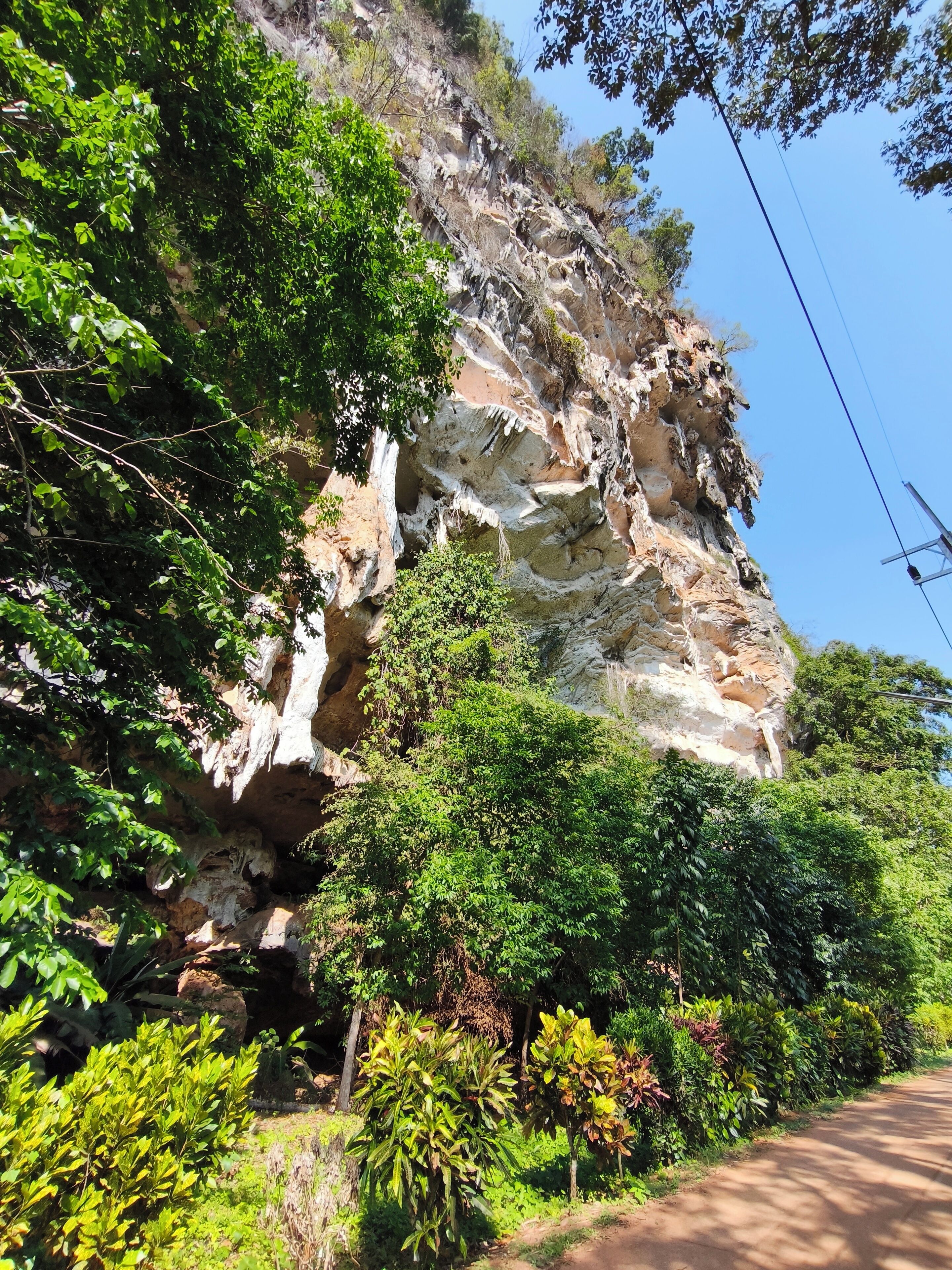 A natural rock formation with greenery around it.