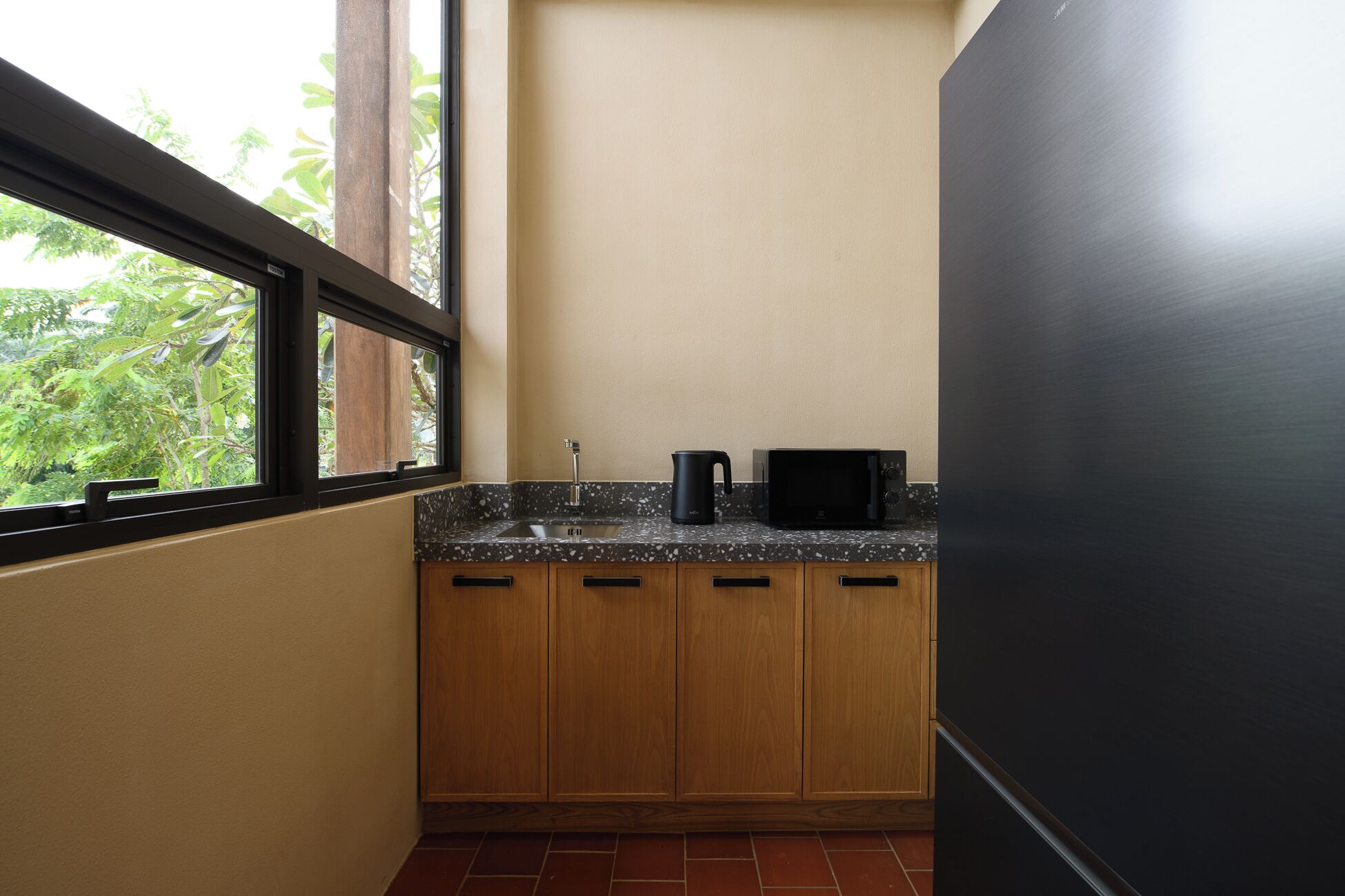 Una cocina compacta con encimera de granito, una cafetera negra y un microondas.