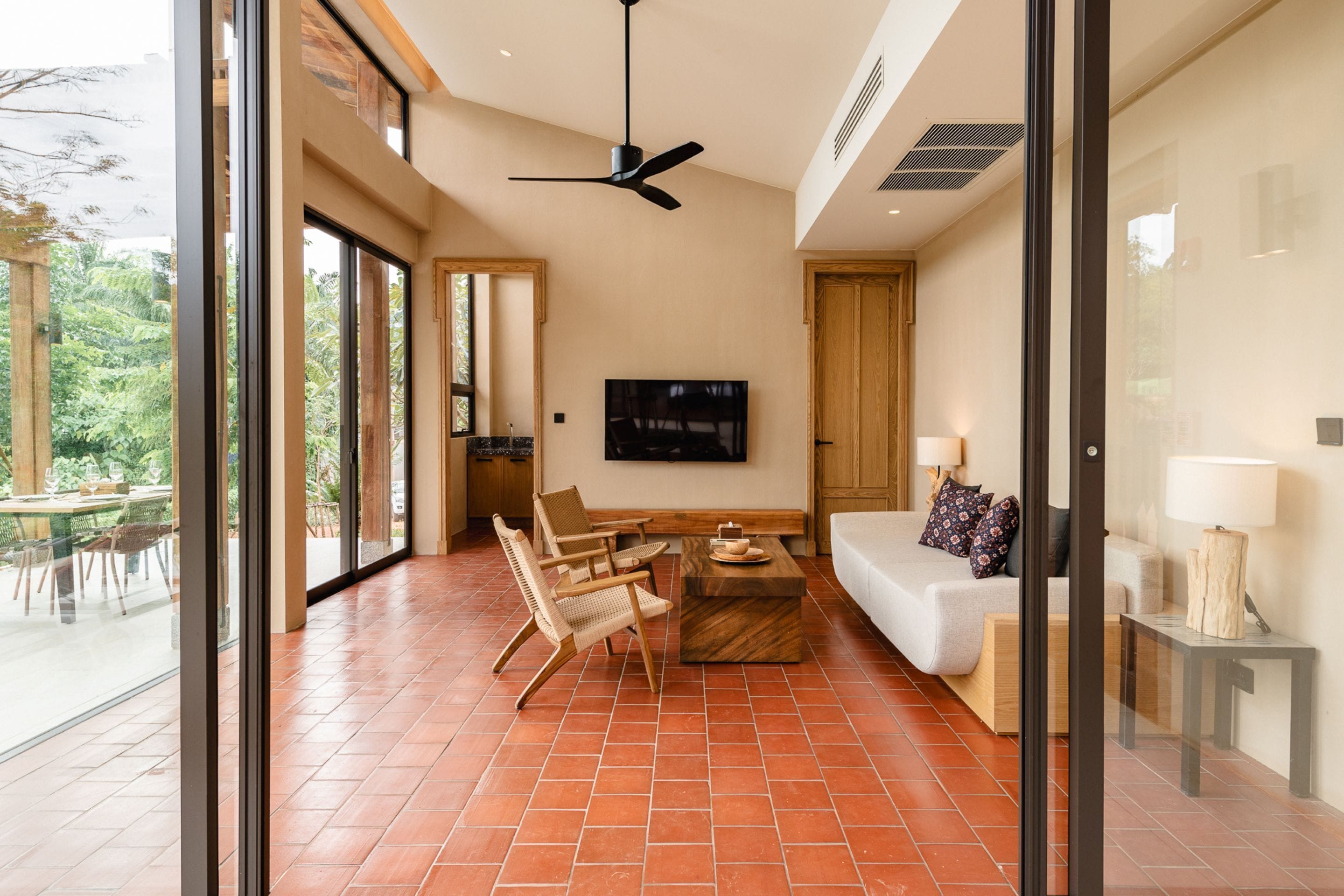 A spacious living area with a large TV, comfortable seating, and a view of the outdoors.