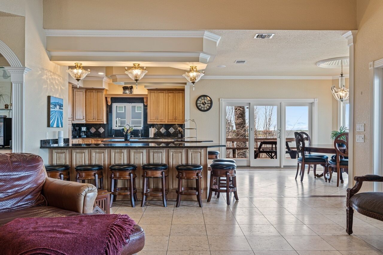 A spacious living room with a large sofa and a dining area with a table and chairs.