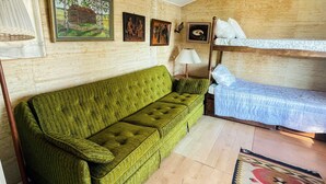 A room with a green sofa, a bunk bed, a lamp, and a rug. - 4 Person Holiday Home in Onsala (Gottskar)